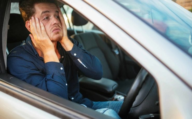 A young man desperately waits in the traffic jam