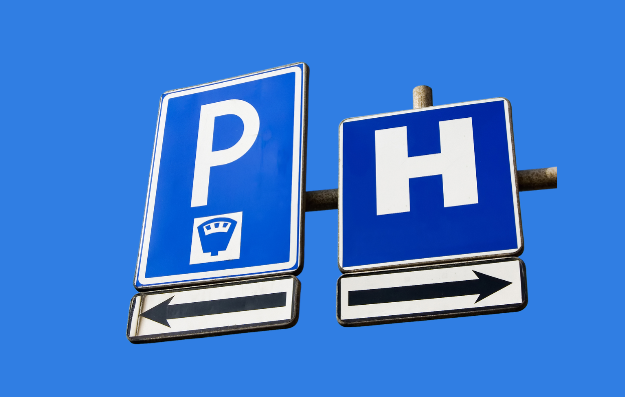 Modern hospital building exterior with red and white signage reading 'Hospital' – representing hospital parking accessibility in Ireland