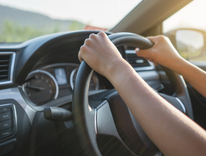 Driver holding the steering wheel of a car, representing how to use an Easytrip tag for tolling and parking.