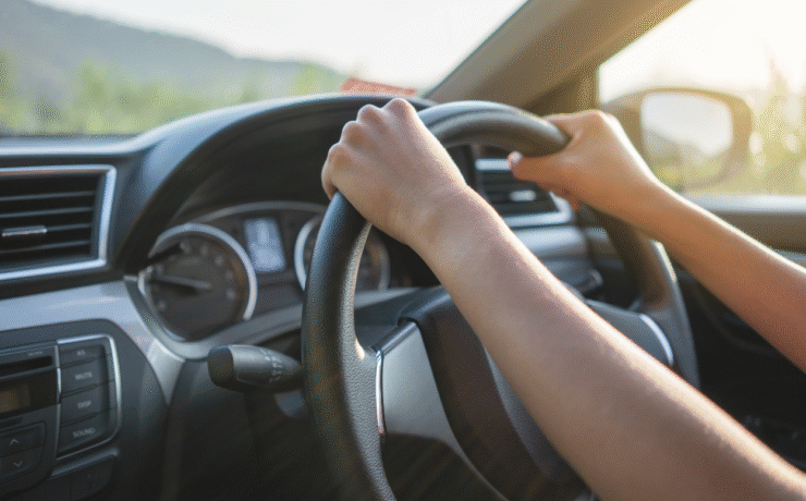 Driver holding the steering wheel of a car, representing how to use an Easytrip tag for tolling and parking.