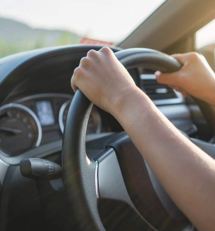 Driver holding the steering wheel of a car, representing how to use an Easytrip tag for tolling and parking.