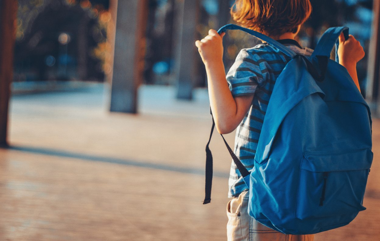 A student carrying a blue backpack ready for school, illustrating back to school tips with Easytrip.