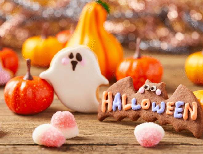 Halloween treats and decorations for midterm break Ireland, including pumpkins and festive sweets on a wooden table.