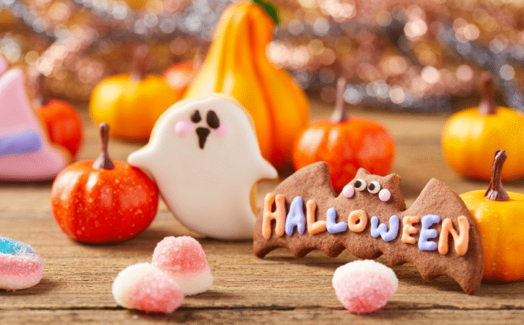 Halloween treats and decorations for midterm break Ireland, including pumpkins and festive sweets on a wooden table.