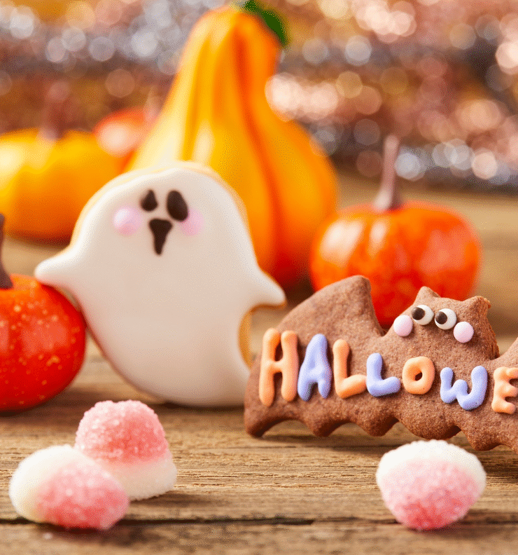 Halloween treats and decorations for midterm break Ireland, including pumpkins and festive sweets on a wooden table.