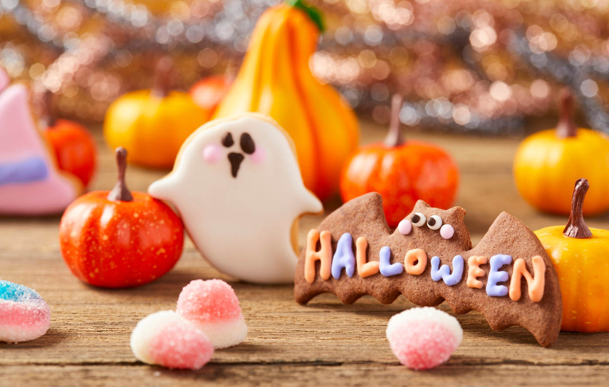 Halloween treats and decorations for midterm break Ireland, including pumpkins and festive sweets on a wooden table.