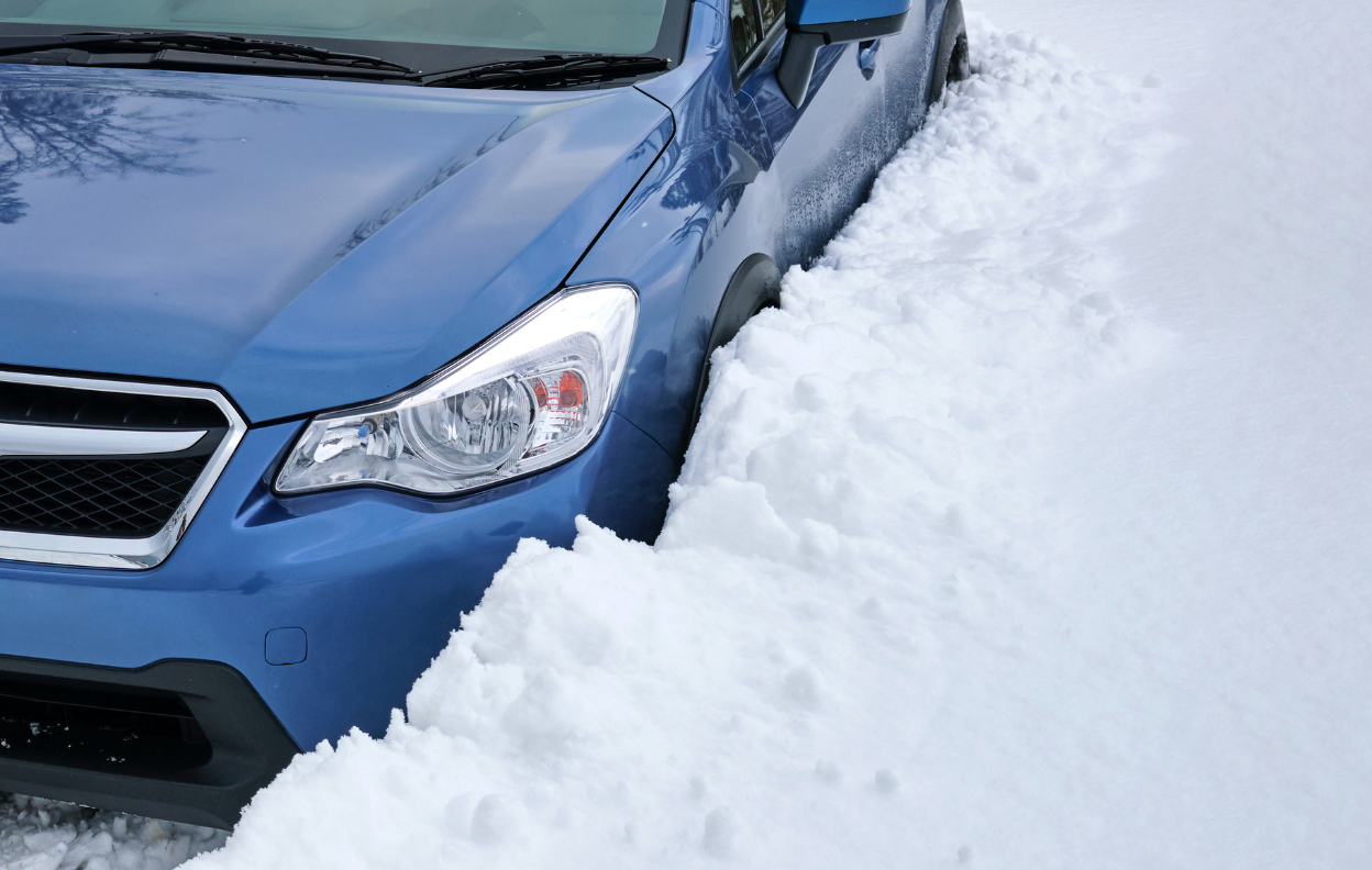 A blue car parked on a snowy Irish road, highlighting Easytrip’s advice to park smarter this winter and stay prepared for cold-weather driving.
