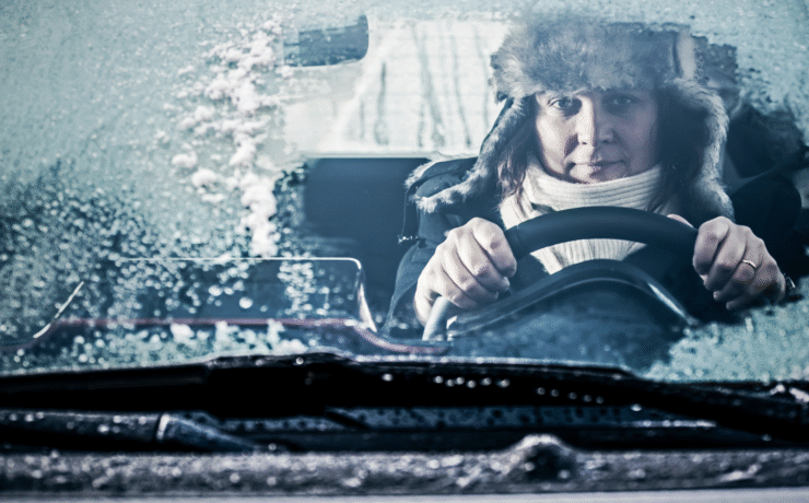 Driver facing icy winter conditions with a frosted windscreen, representing the need for Easytrip winter services for safer, stress-free travel.
