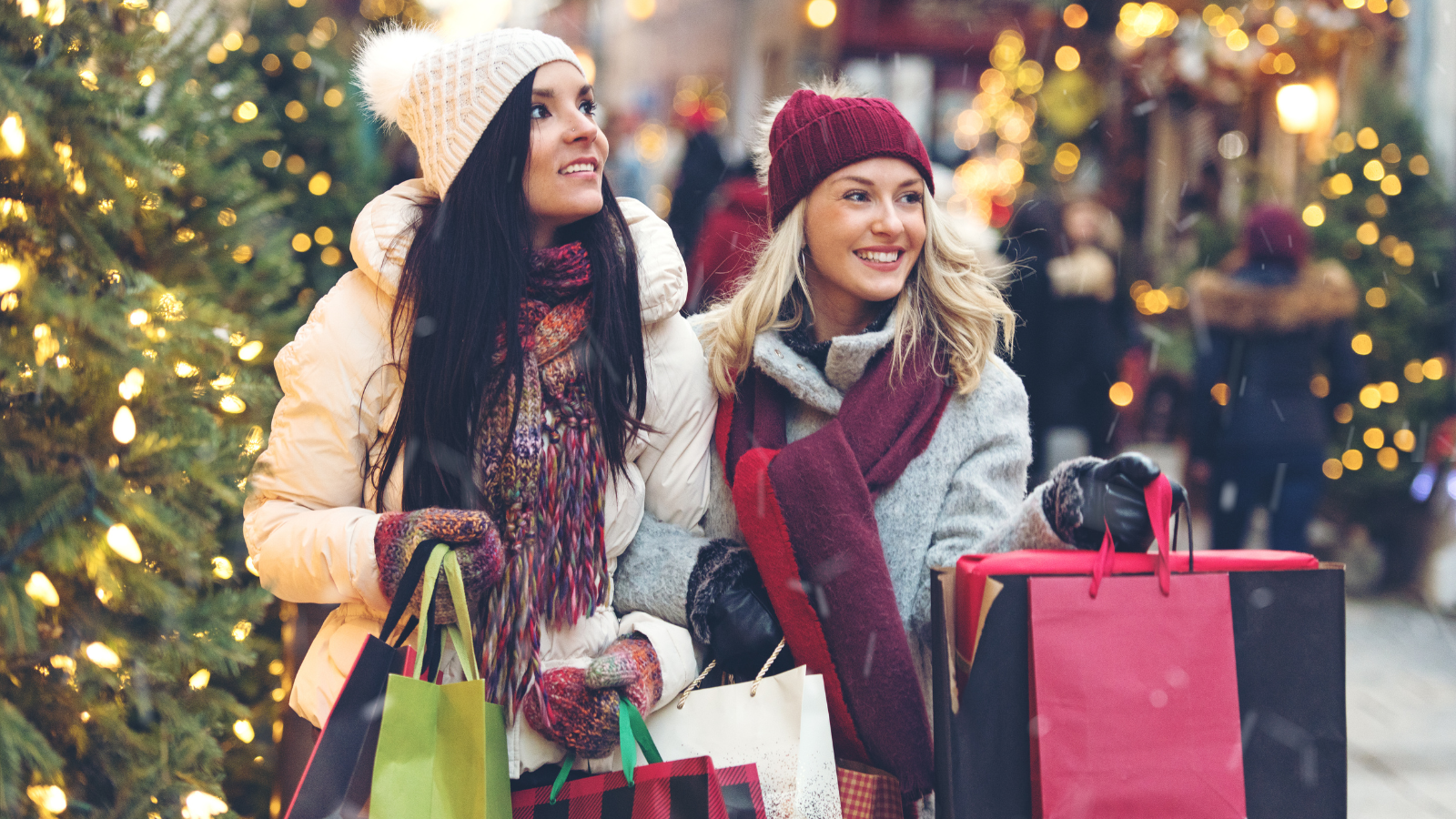 Two women Christmas shopping on a festive street with lights and trees in Dublin – ideal for Dublin Christmas Parking 2025